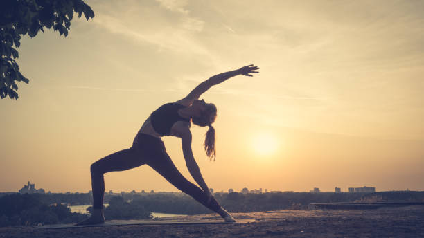 istock Woman practicing yoga outdoors. Summer sunset 1032495712