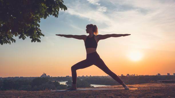 istock Woman practicing yoga outdoors. Summer sunset 1032495718