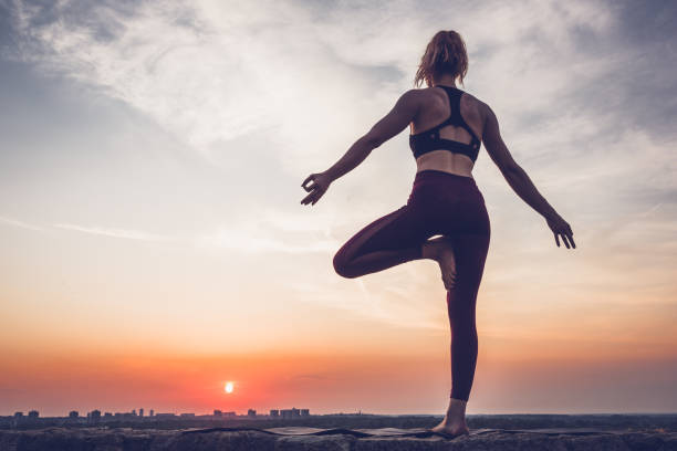 istock Woman practicing yoga outdoors. Summer sunset 1032495770