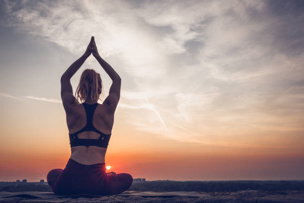 istock Woman practicing yoga outdoors. Summer sunset 1032495776