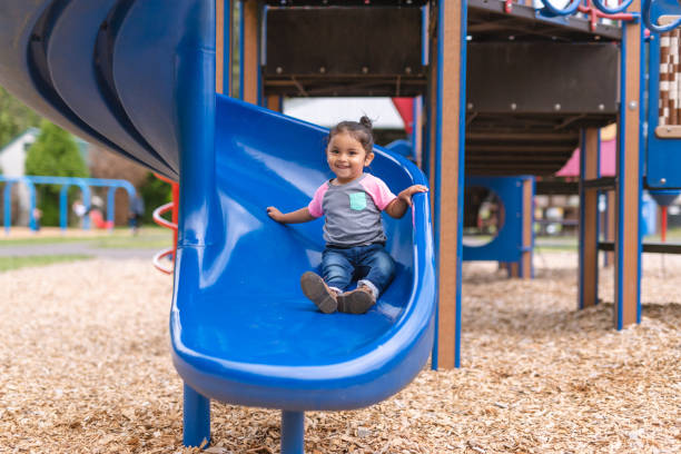 istock A toddler-age girl riding down the slide 1032495834