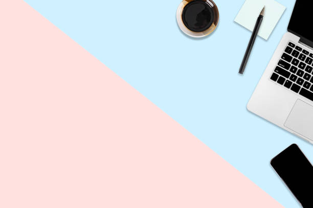 istock Flat lay photo of office table on modern two tone (blue and pink) background. Desktop office mockup concept. 1032495910
