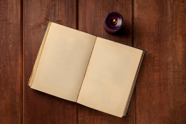 istock An old book with a candle on a dark rustic background with copy space 1032496380