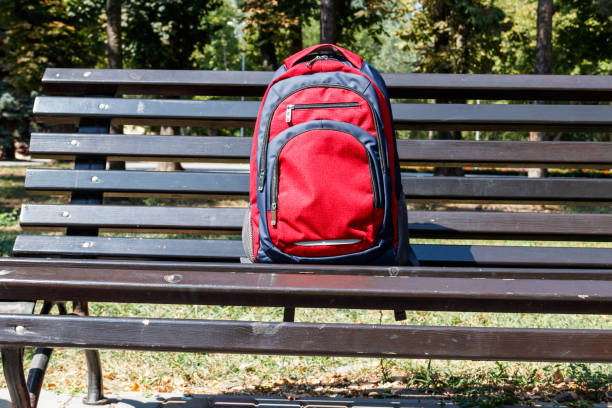 istock Backpack on wooden bench in city park 1032496494