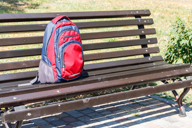 istock Backpack on wooden bench in city park 1032496500