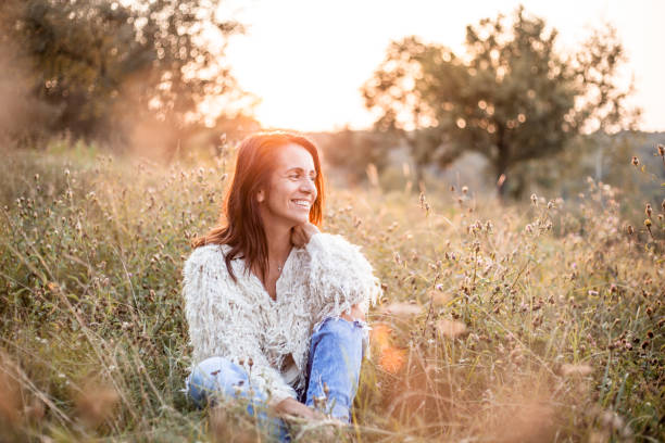 Portrait of a mature woman in park Beautiful woman sitting in the field enjoying the sunset eastern european 50s mature women beauty stock pictures, royalty-free photos & images