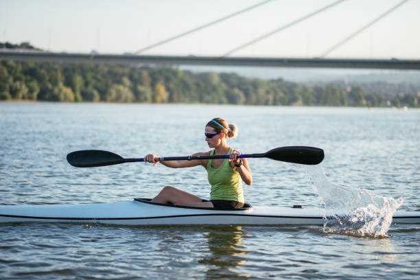 kayaker professionista femminile in kayak in allenamento - women courage water floating on water foto e immagini stock