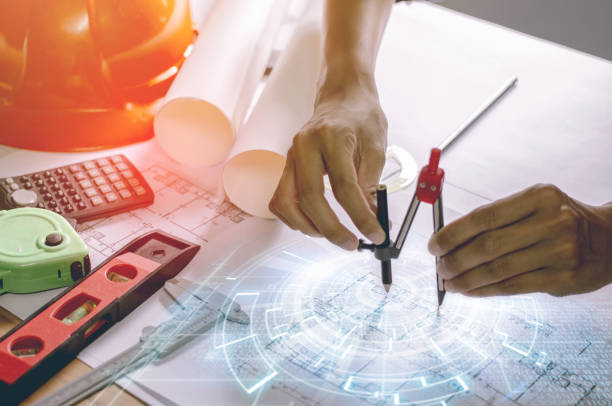 istock Concept architects,engineer holding Circus pointing equipment architects On the desk with a blueprint in the office, Vintage, Sunset light.Selective Focus 1032507658