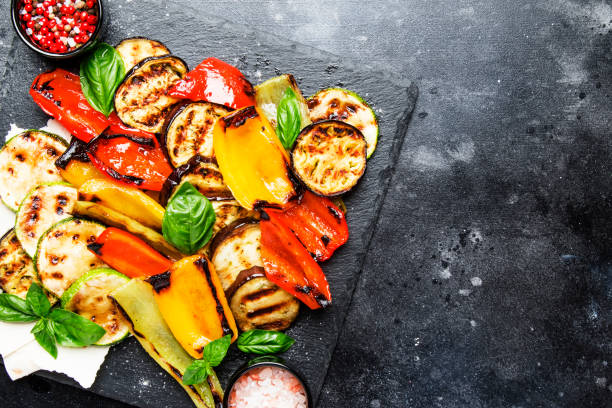 istock Grilled multicolored vegetables, aubergines, zucchini, pepper with green basil on serving stone board 1032512138