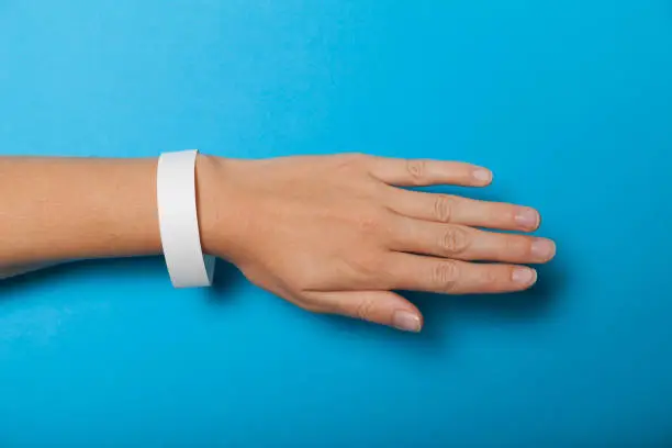 Photo of Paper wristband mockup, event bracelet on hand. Empty ticket wrist band design
