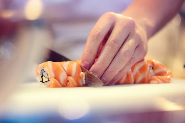 istock Japanese chef at work preparing delicious sushi roll 1032514186