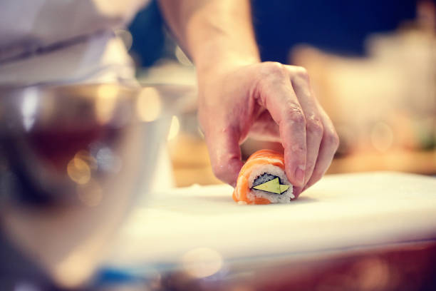istock Japanese chef at work preparing delicious sushi roll 1032514190