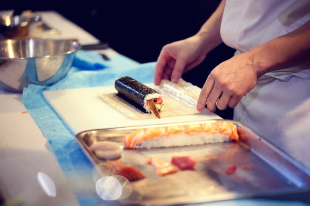 istock Japanese chef at work preparing delicious sushi roll 1032514208