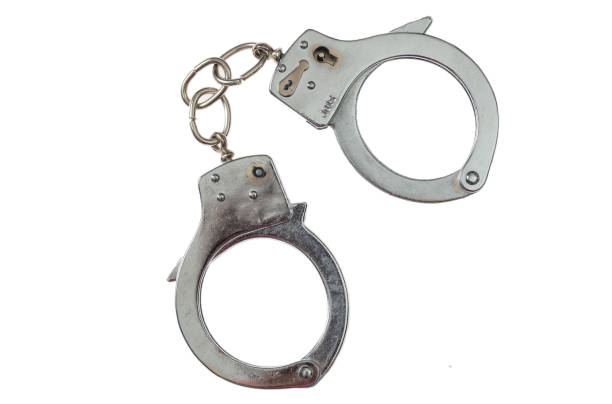 Metal handcuffs isolated on white background, top view Arrest or bontage concept. Metal locked handcuffs isolated on white background, top view cuff stock pictures, royalty-free photos & images