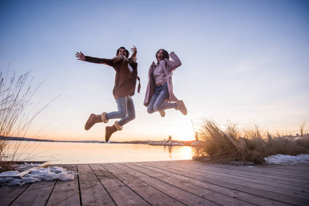 istock Friend jumping on the dock at sunset. 1032524798
