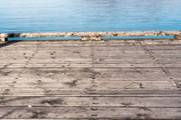 Wooden Boardwalk Jetty Pier with Still Ocean Water with Mountains in Background