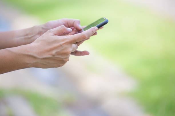 istock Female hand is using a mobile phone On the background blurred 1032527884