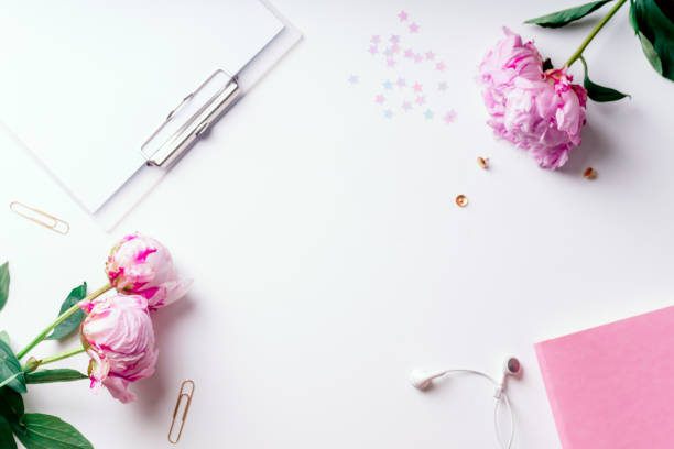 istock Feminine workspace with pink peons on white background with copy space 1032528096