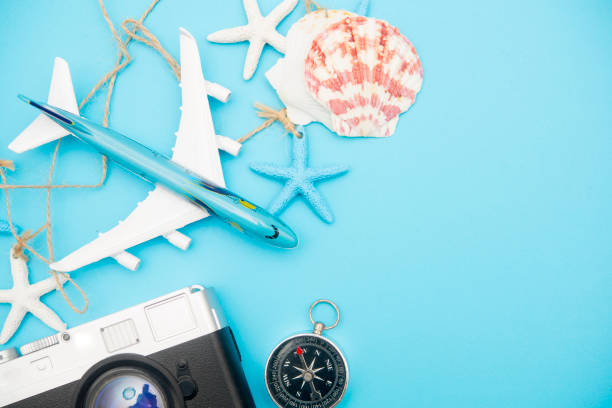 istock blue background with travel decoration,star fish,shell,camera,compass,jig saw map,mini airplane.Top view with copy space, flat lay. minimal style 1032535082