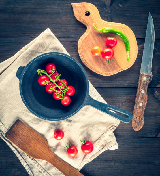 istock cast iron round frying pan and ripe red cherry tomatoes 1032535784