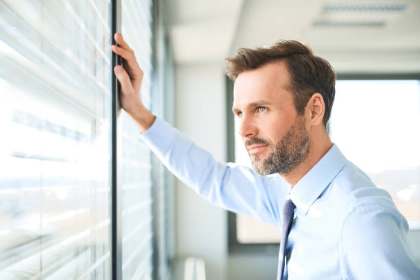 istock Businessman looking through the window at office 1032538906