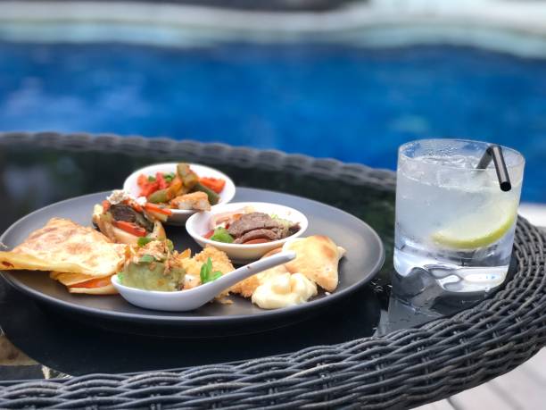 istock pool with mojito annd gin fizz cocktail,luxury setting, afternoon tea snacks 1032539346