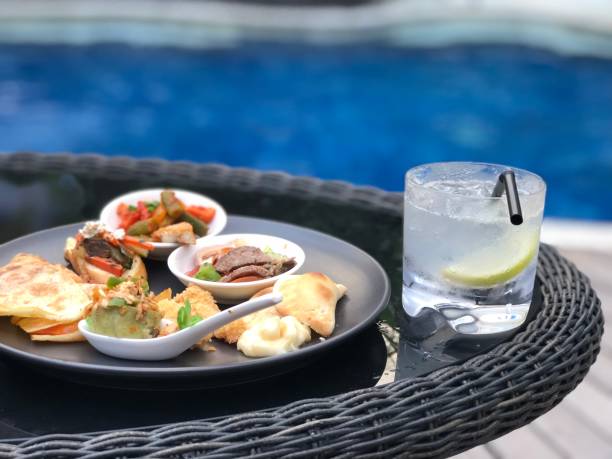 istock pool with mojito annd gin fizz cocktail,luxury setting, afternoon tea snacks 1032539390