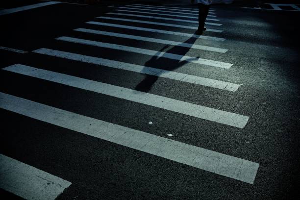 istock Man with long shadow crossing the street 1032545496