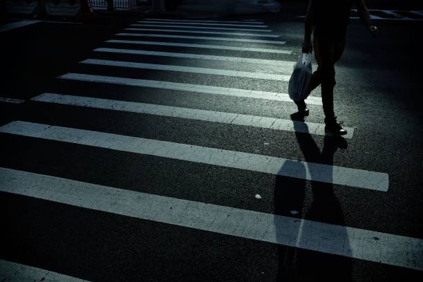 istock Man with long shadow crossing the street 1032545648