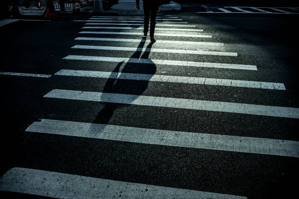 istock Man with long shadow crossing the street 1032547874