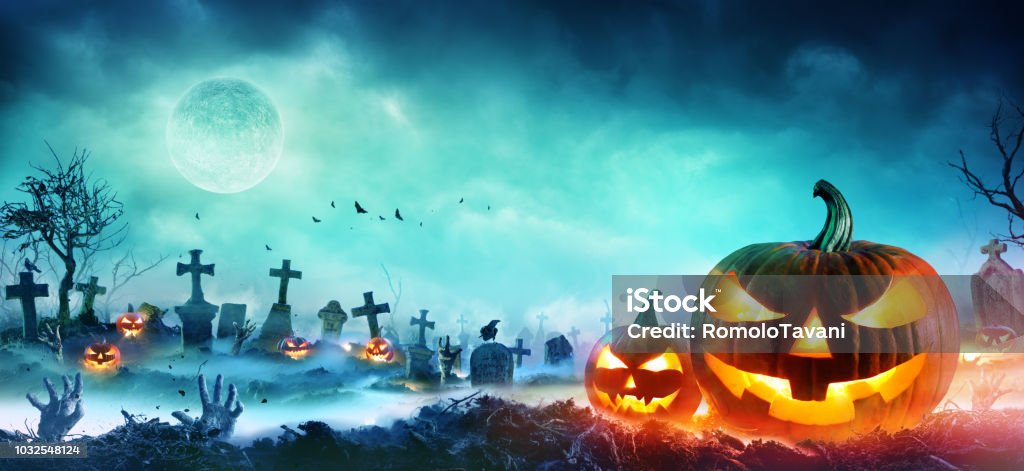 Jack O' Lanterns And Zombie Hands Rising Out Of A Graveyard In Misty Night Pumpkin And Zombie hand In Cemetery Halloween Stock Photo