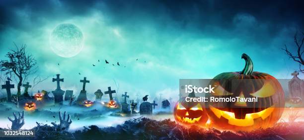 Jack O Lanterns And Zombie Hands Rising Out Of A Graveyard In Misty Night Stock Photo - Download Image Now