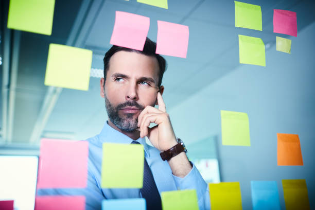 istock Thoughtful businessman in office working on new project looking on adhesive notes 1032553400