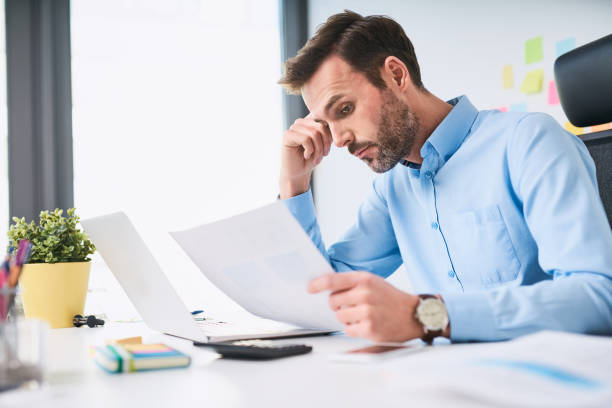istock Unhappy businessman doing paperwork at office 1032555850