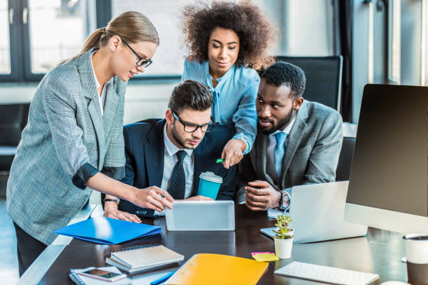 istock multiethnic businesspeople looking at tablet in office 1032560104