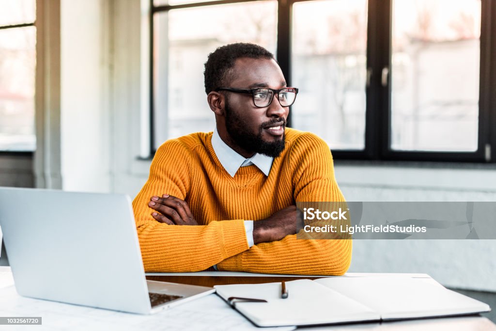 smiling african american businessman with crossed arms in office Office Stock Photo