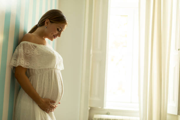 istock Young pregnant woman standing by the wall 1032574246
