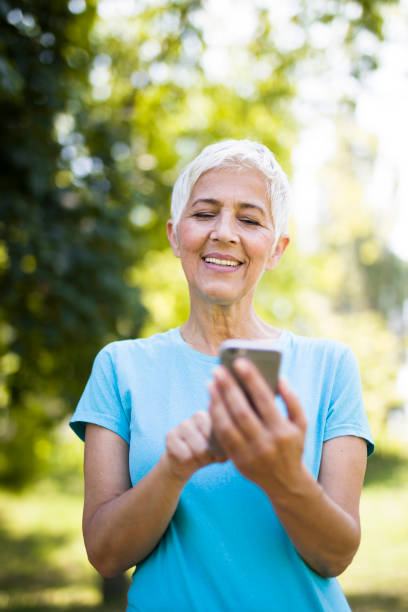 istock Sporty senior woman using mobile phone in the park 1032576748