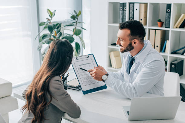 istock general practitioner pointing on insurance claim form to patient in clinic 1032576994