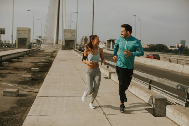 istock Young couple running in urban enviroment 1032578292
