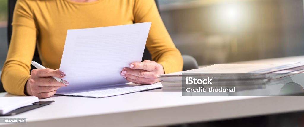 Businesswoman checking document Businesswoman checking document in office Document Stock Photo