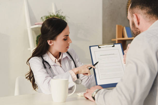 istock female doctor showing insurance claim form to client 1032580992