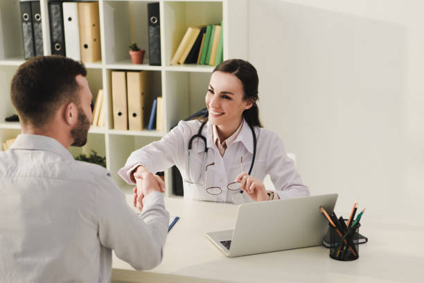 istock client and smiling doctor shaking hands in medical office 1032581038