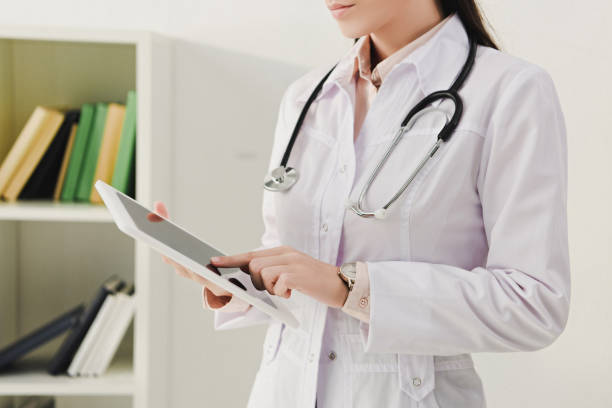 istock cropped view of doctor in white coat with stethoscope using digital tablet 1032581062