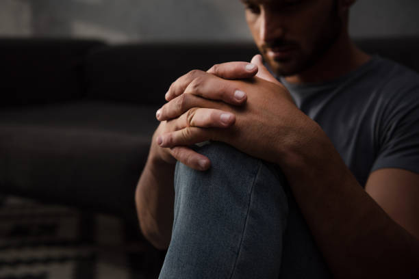 istock sad man sitting on floor at home, selective focus 1032581292