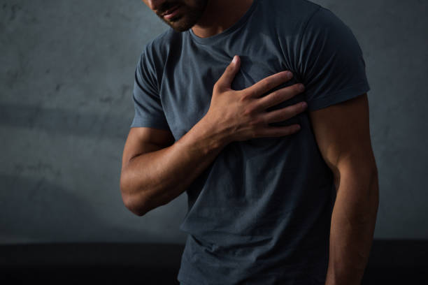 cropped view of man having chest pain and heart attack - chest pain imagens e fotografias de stock