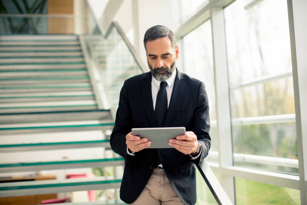 istock Handsome senior businessman with digital tablet in the modren office 1032581872