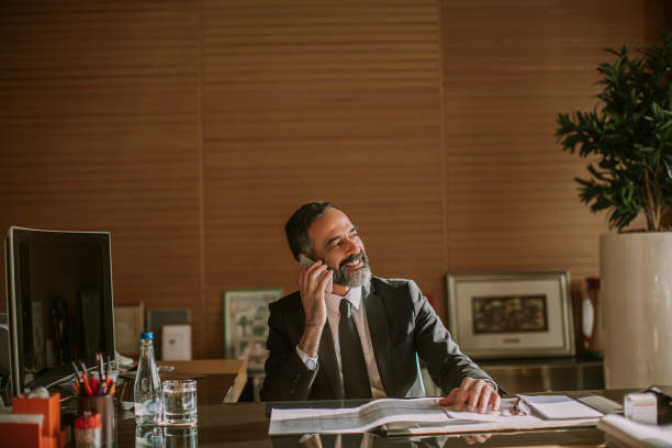 istock Senior businessman using mobile phone and working in modern office 1032581948