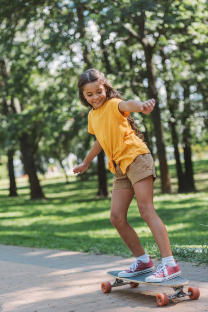 istock adorable happy child riding skateboard in park 1032585776