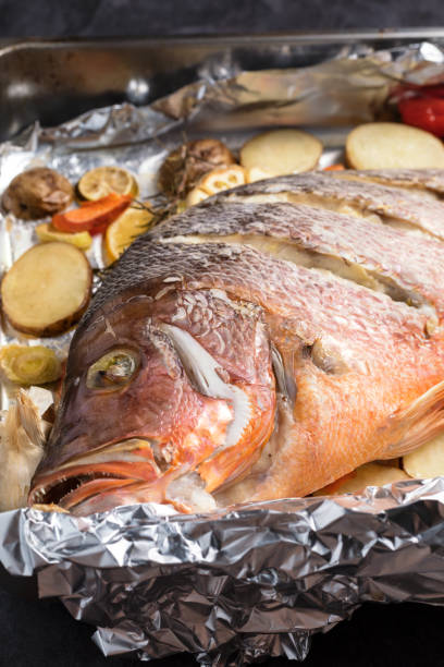 pesce dentice rosso sostenuto dal forno con verdure, solo dal forno, composizione verticale - prepared fish prepared snapper freshness roasted foto e immagini stock